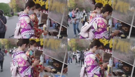穿着和服的年轻女性朋友在街头买食物高清在线视频素材下载