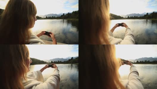 一名女子用手机拍摄山湖景观高清在线视频素材下载