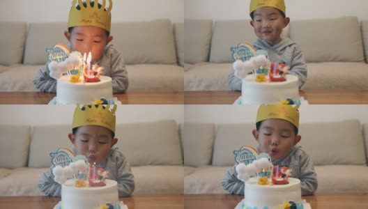 小男孩在吹生日蛋糕上的蜡烛高清在线视频素材下载