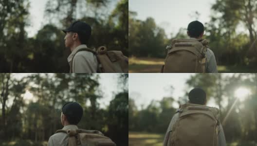 男子在假日里背着背包在树林里徒步旅行。高清在线视频素材下载