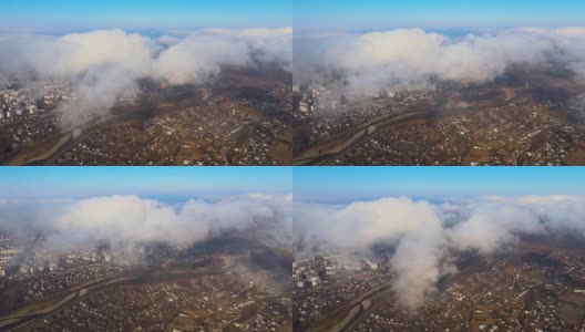 从高空俯瞰，在暴雨来临之前，蓬松的积云覆盖着遥远的城市。多云天气的飞机视角高清在线视频素材下载