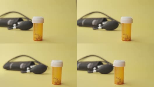橙色和白色的药盒和血压计放在桌子上，高清在线视频素材下载