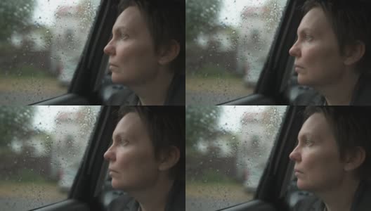 悲伤的女商人等在车里，在雨中看着窗外高清在线视频素材下载