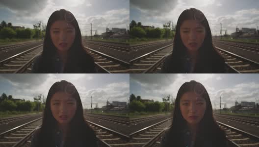 亚洲年轻女子在铁路上哭泣。高清在线视频素材下载