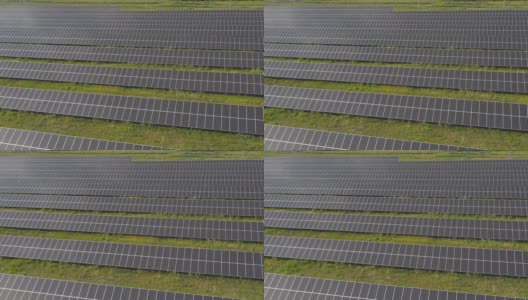 空中拍摄一排排安装在草地上发电的太阳能电池板。从太阳能中获取清洁、环保的能源。现代可再生绿色能源概念。俯视图高清在线视频素材下载