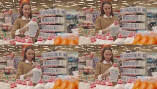 一名女子在超市购物时，用智能手机扫描一瓶洗涤剂上的条形码，查看产品信息和价格高清在线视频素材下载