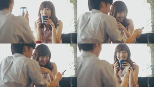 年轻的亚洲女孩为她的男友摆姿势拍智能手机照片高清在线视频素材下载