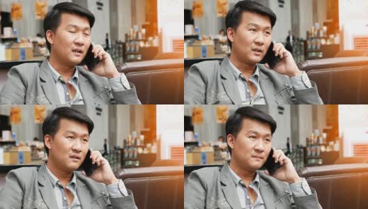 一个亚洲男人坐着打手机高清在线视频素材下载