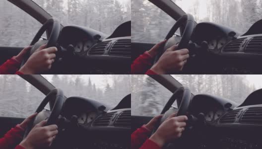 冬天要小心驾驶。黎明时分，女孩驾车沿着白雪覆盖的森林前行。高清在线视频素材下载