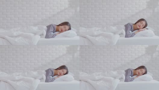 美丽迷人的亚洲女人睡觉和甜蜜的梦躺在床上舒适的卧室早上感觉如此放松和舒适。健康年轻女性在家就寝。医疗保健的概念高清在线视频素材下载