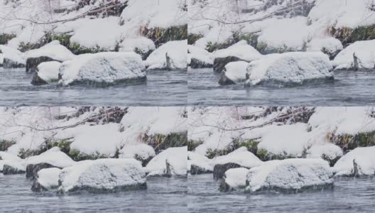 河流或小溪或水流，在冬天有石头和白色的雪帽。大雪纷飞，大雪纷飞高清在线视频素材下载