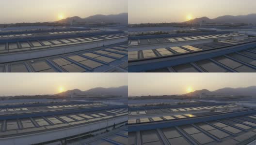 日落时分，安装在大型工厂屋顶上的太阳能电池板的航拍照片高清在线视频素材下载