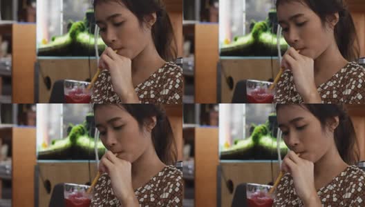 年轻的亚洲女人喝水果冰沙高清在线视频素材下载