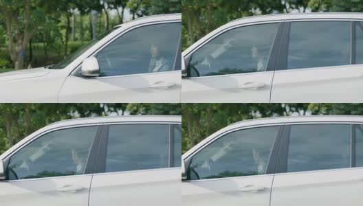一个亚洲人开着一辆车停在户外高清在线视频素材下载