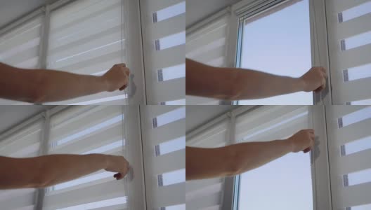 一个男人的手打开窗户上的条纹百叶窗的特写镜头高清在线视频素材下载