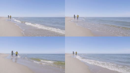 一对幸福的夫妇光着脚在海边散步，享受着自己的生活。白色沙滩。即将离任的沿海线。缓慢的运动。高清在线视频素材下载