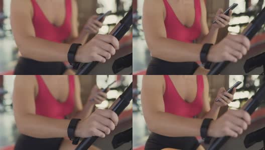 健身器材，带着腕带的苗条女人在健身房骑健身车高清在线视频素材下载