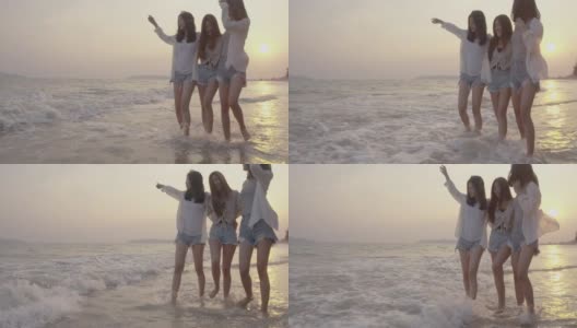 微笑快乐的亚洲朋友群年轻的女人一起走在海边的海滩上夏天度假日落剪影黄昏假日旅游享受生活周末活动人们的生活方式，慢镜头4K高清在线视频素材下载