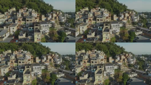 在巴西里约热内卢，日出时，空中追踪经过山顶上阳光明媚的贫民窟房屋高清在线视频素材下载