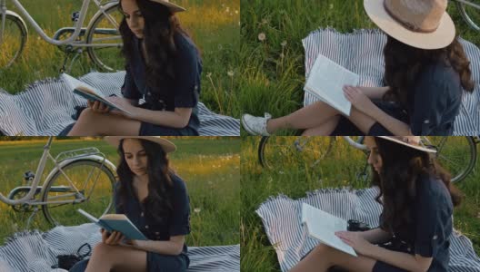 SLO MO MS年轻女人在野餐毯子上看书高清在线视频素材下载
