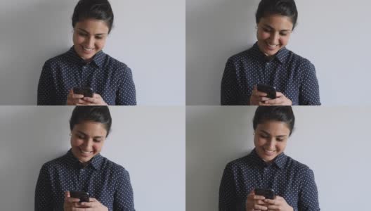 沉迷于科技的年轻印度裔女性使用手机应用。高清在线视频素材下载