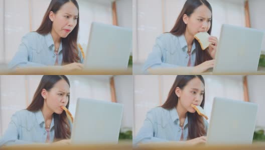 亚洲有吸引力的女商人饿着吃面包满嘴匆忙时间在笔记本电脑上运行业务。美丽认真的学生感到沮丧和忙于工作和学习在家里高清在线视频素材下载