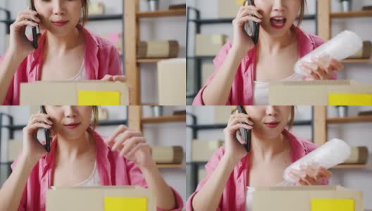 年轻的亚洲女商人使用移动电话接收采购订单和检查产品库存，在家庭办公室工作。高清在线视频素材下载