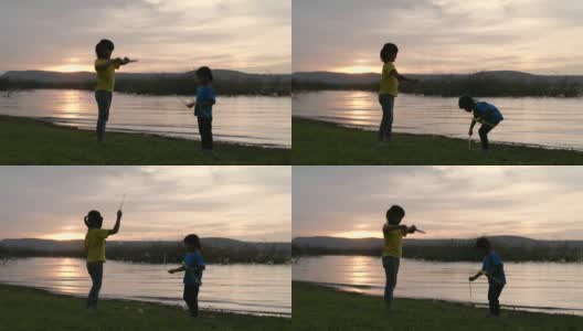 亚洲两个孩子在日落时在湖边玩泡泡的场景，快乐的时光，为孩子们的节日活动高清在线视频素材下载