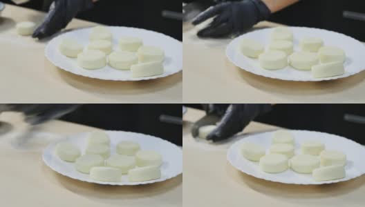 糕点师用抹刀制作圆形凝乳，然后把它们放在盘子里。高清在线视频素材下载