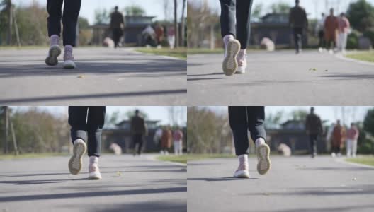 慢动作低角度跟随一个年轻女子在公园跑步的镜头高清在线视频素材下载