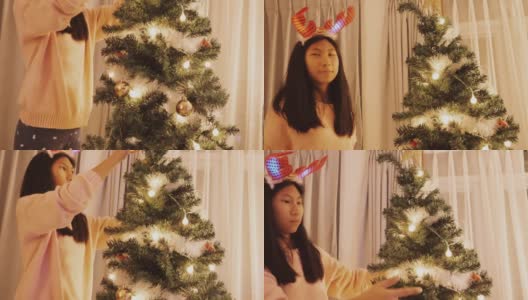 快乐的亚洲女孩戴着驯鹿发带，晚上在家装饰圣诞树，庆祝节日的概念。高清在线视频素材下载
