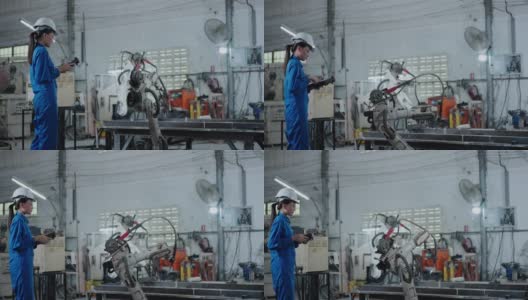 女工程师用遥控器操作机器人手臂。高清在线视频素材下载