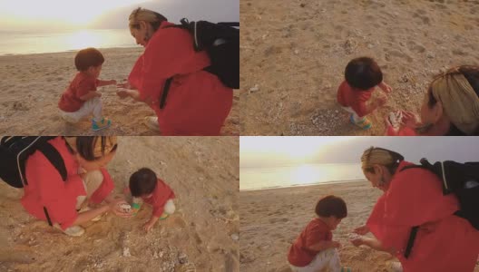 妈妈和女儿在沙滩上玩。高清在线视频素材下载