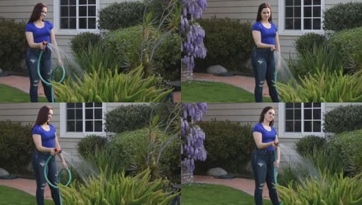 年轻女子给花园浇水高清在线视频素材下载
