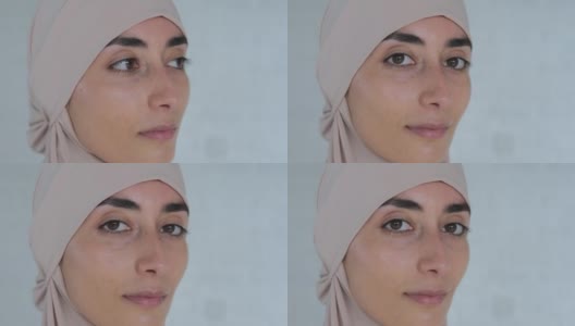 年轻漂亮的穆斯林女子自信地微笑着，戴着伊斯兰教的头巾，脸上露出快乐可爱的表情。根据伊斯兰教法，女性的生活受到权利和自由的限制高清在线视频素材下载