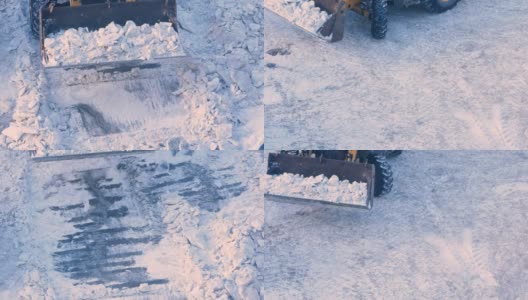 一辆带着铲斗的推土机正在清除城市道路上的冰雪。清理积雪对街道的影响。用扫雪机清理道路。拖拉机清理积雪的工作高清在线视频素材下载