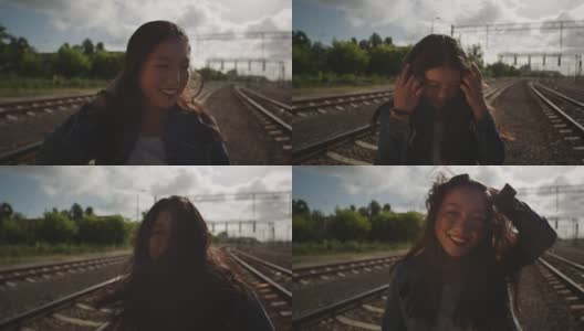 亚洲年轻女子在铁路上抛洒头发。高清在线视频素材下载
