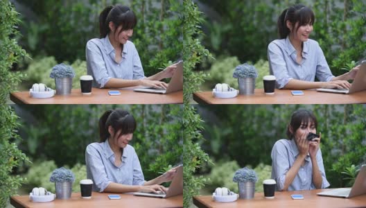 亚洲年轻女子坐在工作场所，在花园里使用笔记本电脑高清在线视频素材下载