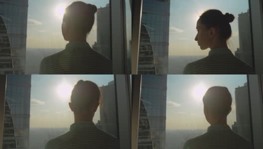 透过摩天大楼的后视镜，沉思的女人在看城市风景高清在线视频素材下载
