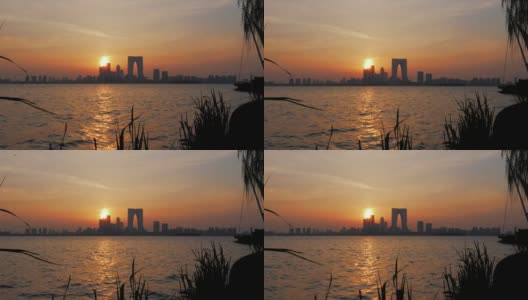 中国苏州- 2019年3月30日:日落时的天际线全景，城市摩天大楼在湖面上倒影高清在线视频素材下载