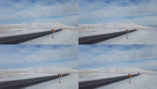 广角拍摄的汽车行驶在冰岛路上，雪山和日落乡村，冬天的时间。4 k高清在线视频素材下载