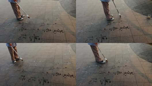用毛笔在地上的广场上写字高清在线视频素材下载