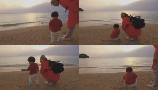 妈妈和女儿在沙滩上玩。高清在线视频素材下载