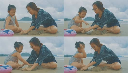 亚洲年轻的母亲和她的女儿在沙滩上玩沙子高清在线视频素材下载