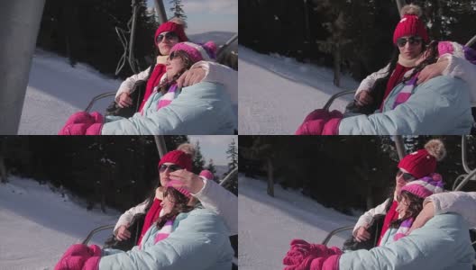 母亲和女儿在寒假乘坐滑雪缆车高清在线视频素材下载