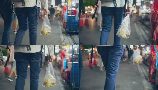 亚洲背包客的背影，拿着食物，走在市场上。年轻活跃帅气的旅行者男性独自在夜晚的街道上旅行，享受在美丽的城市度假旅行的时间高清在线视频素材下载