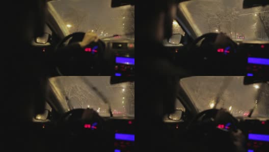 一个年轻人在暴风雪的夜晚开车。高清在线视频素材下载