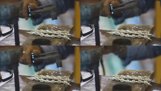 男人手工制作的银项链用煤气燃烧来粘合高清在线视频素材下载