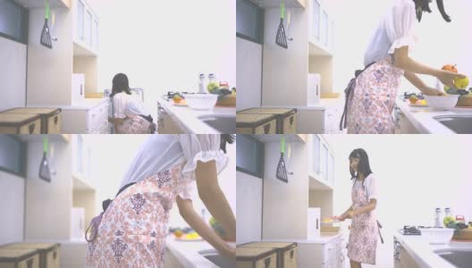 年轻女子在厨房里准备水果和蛋糕高清在线视频素材下载