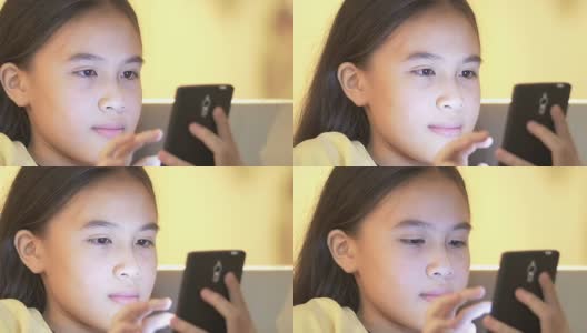 一个年轻的亚洲女孩使用智能手机的特写高清在线视频素材下载